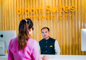 BloomSuites I Electronics City في بانغالور: امرأة تتحدث إلى رجل أمام مكتب