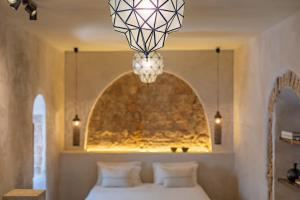 a bedroom with a bed and a chandelier at The Riad - Adults Only in Tarifa