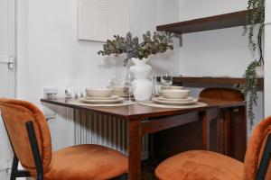 a dining room table with plates and a vase on it at Bright & modern Islington 2BD apt for 6 in London