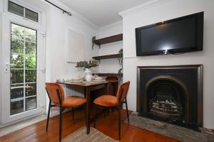 a dining room with a table and a fireplace at Bright & modern Islington 2BD apt for 6 in London