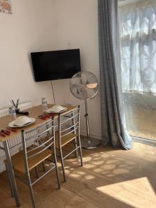 a dining room with a table and a fan at Midland road studio in Wellingborough