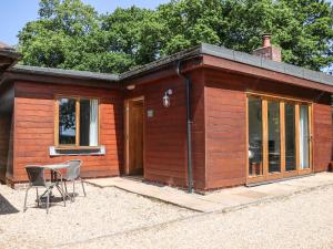 ein kleines Holzhaus mit einem Tisch und Stühlen in der Unterkunft Badgers Sett in Fareham