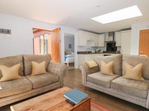 a living room with two couches and a kitchen at Badgers Sett in Fareham