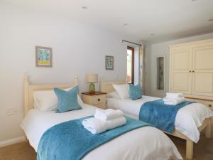 a bedroom with two beds with blue and white sheets at Badgers Sett in Fareham
