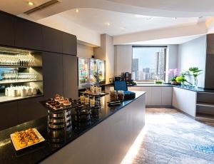 a restaurant with a counter with food on it at M Hotel Singapore City Centre in Singapore