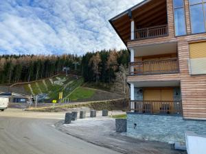a building with a balcony on the side of a road at Apartment Fastenberg Schladming - Top11 by AA Holiday Homes in Schladming