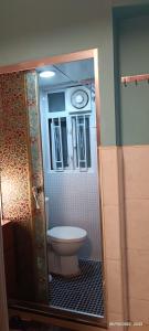 a bathroom with a toilet inside of a bathroom stall at The Cultural Crashpad - 康乃馨旅館 in Hong Kong