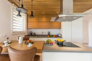 a kitchen with wooden cabinets and a table with fruits on it at SOFIA Luxury Residence in Paphos