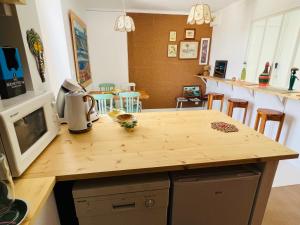 a kitchen with a wooden counter top with a microwave at Coco bay in Saint-Benoît-des-Ondes