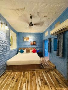 a bedroom with a large bed with blue walls at Rani Mahal in Jodhpur
