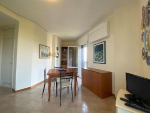 a living room with a table and a dining room at Appartamento con vista panoramica e piscina in Lignano Sabbiadoro