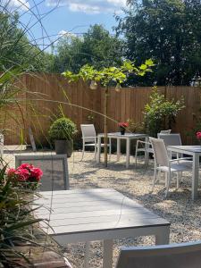 a patio with tables and chairs and a fence at Huize Hölterhof Wellness Hotel Restaurant in Enschede