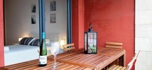 a wooden table with a bottle of wine and a glass at Apartament Julia in L'Eucaliptus