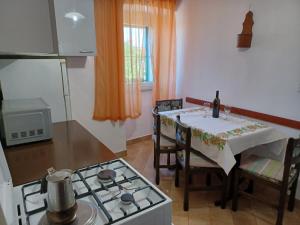 a kitchen with a table and a stove and a table and chairs at VIKTOR I SILVANA in Cres