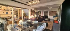een woonkamer met een glazen tafel en stoelen bij The View Beach Penthouse in Limassol