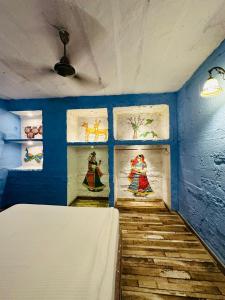 een blauwe kamer met schilderijen aan de muren bij Rani Mahal in Jodhpur