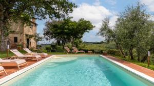 a swimming pool with chairs and a house at Villa Caterina 8, Emma Villas in San Gimignano