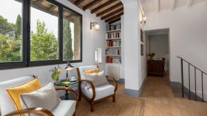a living room with a couch and chairs and a book shelf at Villa Caterina 8, Emma Villas in San Gimignano