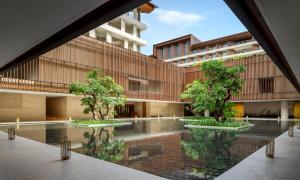 an external view of a building with trees in a courtyard at The Taikang Sanya, a Tribute Portfolio Resort in Sanya