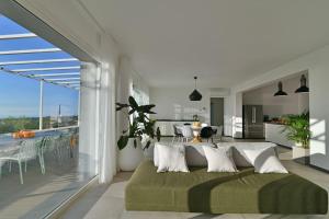 uma sala de estar com um sofá e uma sala de jantar em Modern Villa, pool + gym em Giarre