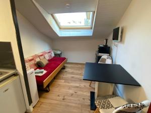 salon z kanapą i stołem w obiekcie Les studios meublés de l'avenue Bouloumié Vittel w mieście Vittel