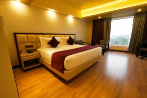 a hotel room with a bed and a large window at Fort Manor in Trivandrum