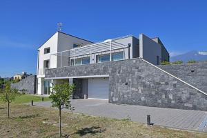 uma casa grande com uma parede de pedra em Modern Villa, pool + gym em Giarre