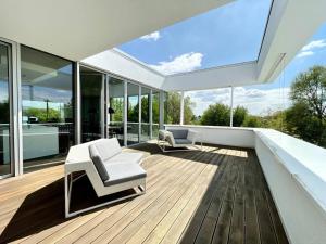 een open terras met witte meubels op een huis bij Luxury Villa EMG Frankfurt Heidelberg - Bensheim in Bensheim