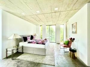 een slaapkamer met een bed, een tafel en een stoel bij Luxury Villa EMG Frankfurt Heidelberg - Bensheim in Bensheim