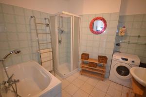 ein Badezimmer mit einer Dusche, einem Waschbecken und einer Waschmaschine in der Unterkunft Casa Ginny in Orta San Giulio