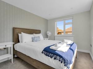 a bedroom with a large bed and a window at Pass the Keys Flat 1 Elegance Meets Modern Luxury in Whitstable