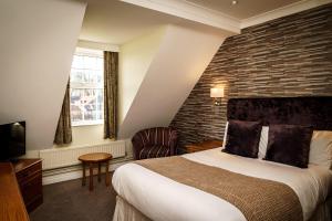 een hotelkamer met een bed en een bakstenen muur bij The Bridge Hotel and Spa in Wetherby