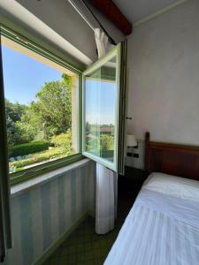 a bedroom with a bed and a large window at Locanda Maison Verte in Cantalupa