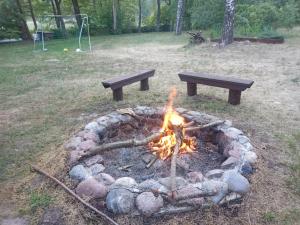 a fire pit with two benches and a picnic table at Zalesie z pomostem I in Barczewo