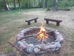 una hoguera con dos bancos y una mesa de picnic en Zalesie z pomostem I, en Barczewo