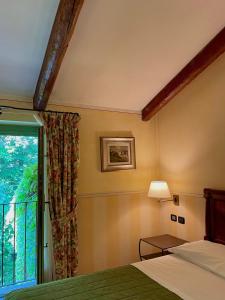een slaapkamer met een bed en een raam bij Locanda Maison Verte in Cantalupa