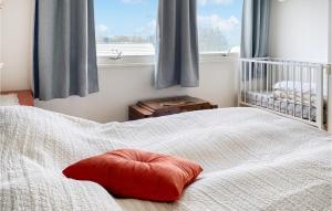 Una cama con una almohada roja delante de una ventana en Stunning Home In Kjerstad With Wifi, en Kjerstad