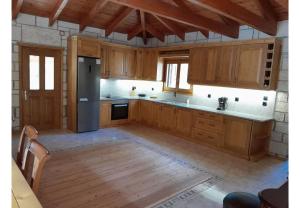 a kitchen with wooden cabinets and a stainless steel refrigerator at Tsarouxi village 1 in Karditsa