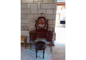 a dressing table with a mirror and a stool at Tsarouxi village 1 in Karditsa
