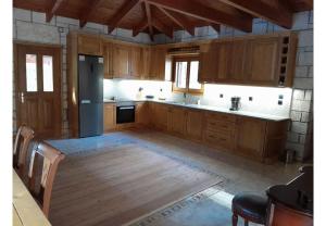 a kitchen with wooden cabinets and a black refrigerator at Tsarouxi village 1 in Karditsa