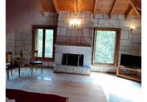 a living room with a fireplace and a tv at Tsarouxi village 1 in Karditsa