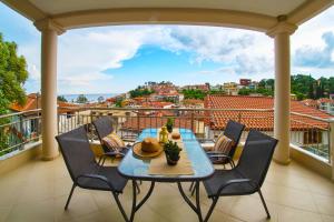 a table on a balcony with a view of a city at Anthi Luxury Apartments in Parga