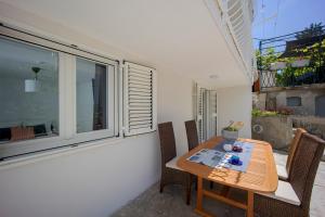 a table and chairs in a room with a window at Apartments Batista in Trogir
