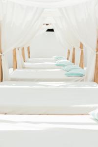 a row of bunk beds with white drapes at Cavo Bianco Boutique Hotel & Spa in Kamari
