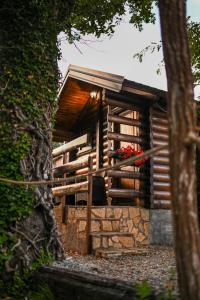 a wooden cabin with a window and a chair at Via river in Podgorica