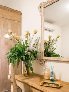 un vaso di fiori su un tavolo di fronte a uno specchio di Villa Diletta b&b a Forte dei Marmi