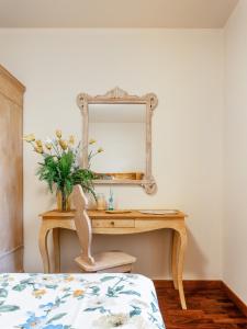 Villa Diletta b&b في فورتي دي مارمي: غرفة نوم مع طاولة تزيين مع مرآة