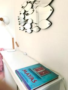 a book on a table with a butterfly on the wall at Sweet Room 15 in Paris