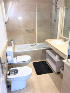 uma casa de banho com um WC, um lavatório e um chuveiro em Modern apartment with pool on the beachfront in Marbella by SharingCo em Marbella