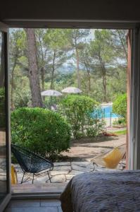 een slaapkamerraam met uitzicht op een tuin bij Hôtel La Pinède in Saint-Marcellin-lès-Vaison